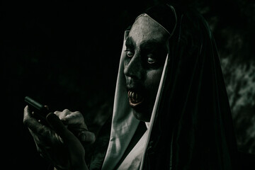 evil nun using her smartphone