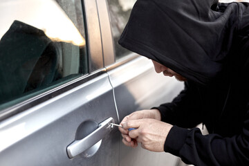 Unrecognizable Car thief steal car breaking door criminal job burglar Hijacks Auto thief is trying...