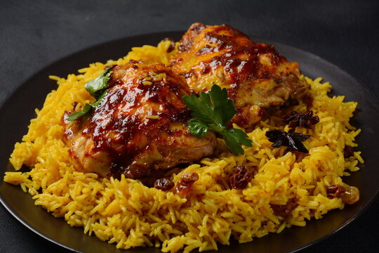 The national Saudi Arabian dish chicken kabsa with roasted chicken quarter and almonds, raisins, garlic and biryani rice