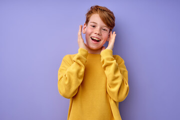 red-haired boy with wide open eyes is surprised. True human feelings and reaction. Crazy excited teenage boy making funny face, opening mouth widely and gesturing emotionally, expressing astonishment