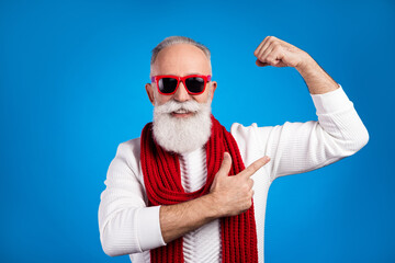 Photo of strong funny mature man dressed white pullover red glasses pointing finger arm muscle isolated blue color background