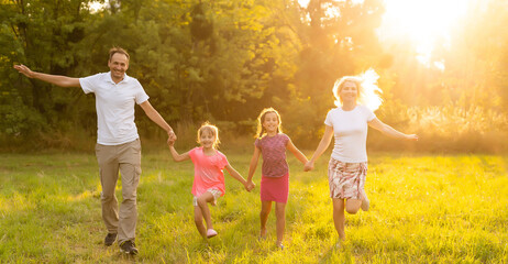 Fototapeta na wymiar Happy family enjoying life together at meadow outdoor.