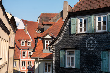 Colored medieval houses with red tile roofs in Bamberg city center on a sunny summer day