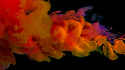 Colored cloud of ink on a black background. Drops of yellow, purple and scarlet ink in water. Scarlet, yellow, purple watercolor paints in water on a black background. Awesome abstract background.
