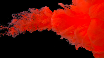 Orange ink droplets in water. Cosmic star background. Orange-pink watercolor paints in water on a black background. Beautiful wallpaper for your desktop.