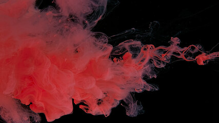 Drops of pink ink in water. Pink watercolor paints in water on a black background. Awesome abstract background. Beautiful wallpaper for your desktop.