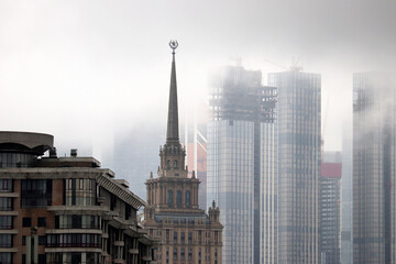 Rain and fog in Moscow. View to Stalin high rise building and skyscrapers of Moscow international business centre in clouds