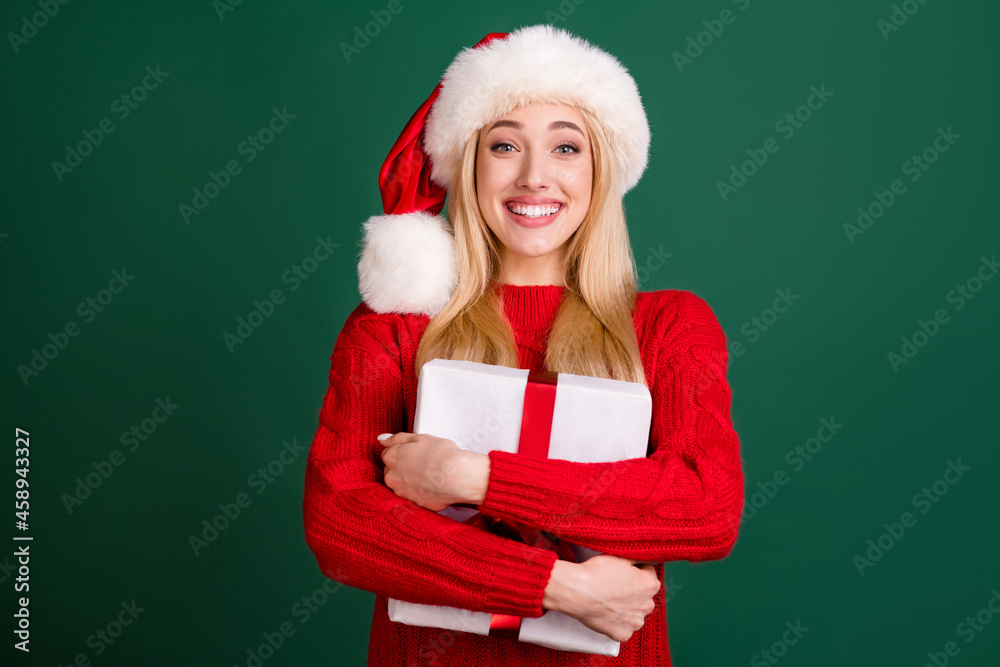 Sticker Photo of positive charming happy young woman hug gift box christmas holiday isolated on green color background