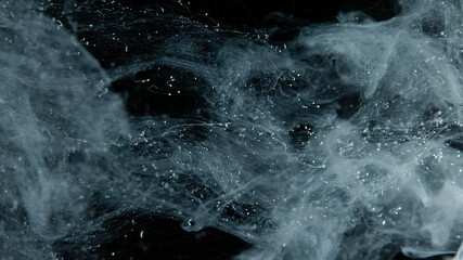 White cloud of ink on a black background. Drops of white ink in water. Awesome abstract background. Beautiful wallpaper for your desktop. White cloud of ink on a black background. 