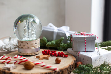 Christmas decorations, a snow globe and presents and star shaped biscuits.