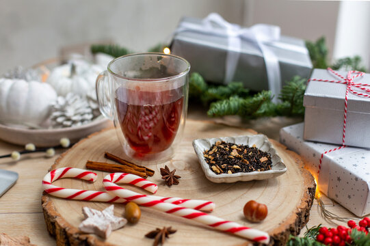 Christmas, a glass of mulled cider or wine with spices, candy canes and decorations.