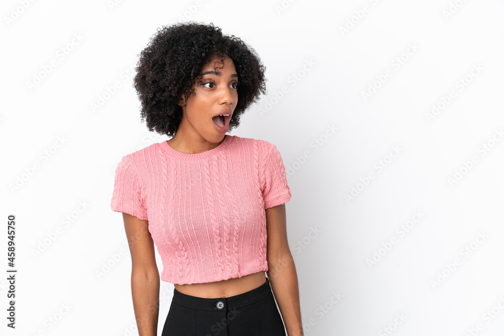 Canvas Prints Young African American woman isolated on white background doing surprise gesture while looking to the side