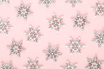 Christmas background. White snow decorations on a pink background.