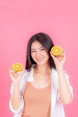 beauty woman Asian cute girl feel happy holding orange fruit for good health on pink background with copy space - lifestyle healthy woman concept