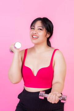 Asian fat women , Fat girl , Chubby, overweight plus size Exercises with dumbbell lifting isolated on pink background - lifestyle Woman diet weight loss overweight problem concept