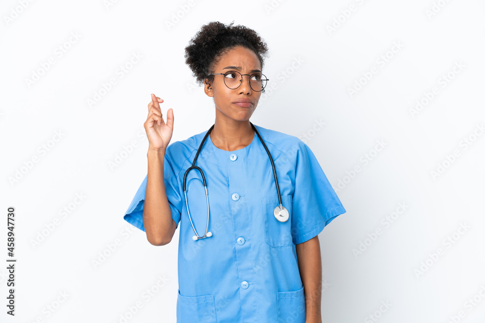 Sticker Young surgeon African American doctor woman isolated on white background with fingers crossing and wishing the best