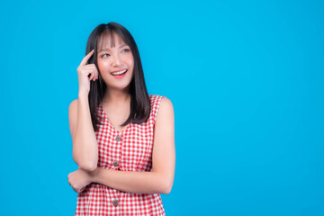 Young beautiful Asian woman pointed a finger to her head and smiled isolated on green background ,She think that she is coming up with new plans to get her work done - thinking woman concept