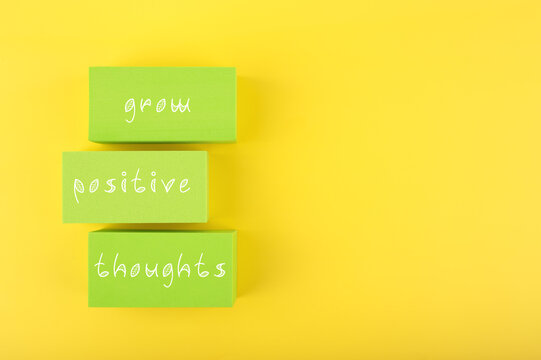 Naklejki Positive affirmation, mental health or quote concept. Grow positive thoughts written on green rectangles on yellow background with copy space. Motivational text for inner piece