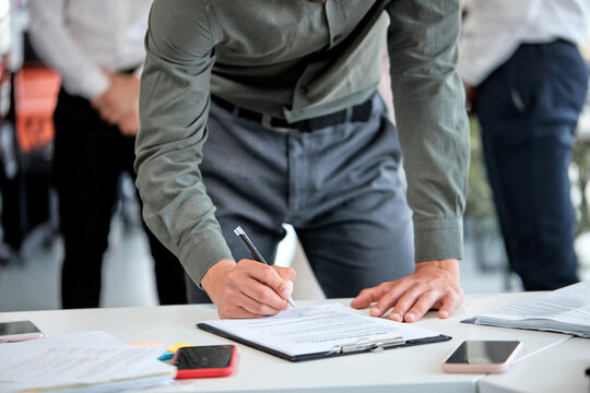 Cropped business man signing financial contract, put write signature on legal corporate paper fill document form buy insurance loan, making business agreement, close up view hands. copy space