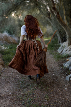 Witch with broom running in woods