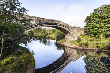 Fototapeta na wymiar Old Lanercost Bridge built of red sandstone over the River Irthing in 1724 at Lanercost, Cumbria UK