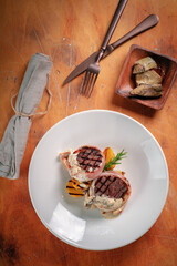Grilled beef steak with mushroom sauce and potatoes served on a plate. Grilled meat tenderloin, top view