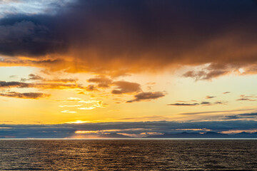 Fototapeta premium A sunset over the NW Pacific coast near Prince of Wales Island, Alaska, USA - Viewed from a cruise ship sailing the Inside Passage