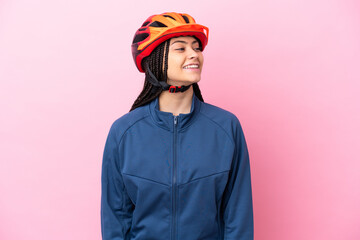 Teenager cyclist girl isolated on pink background looking side - obrazy, fototapety, plakaty