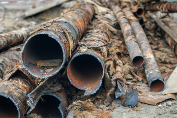 Used rusty metal pipes taken out of the ground. Selective focus. 