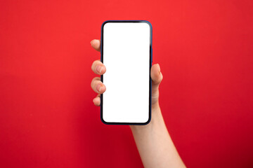Mockup of mobile phone in hand on bright red colored background, copy space photo