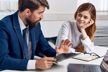 business man and woman sitting at the table in front of laptop office technology