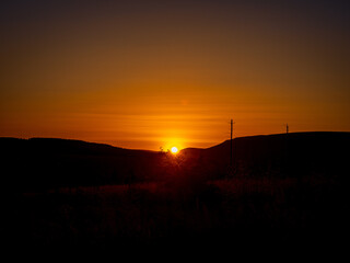 Sun sets over the hill