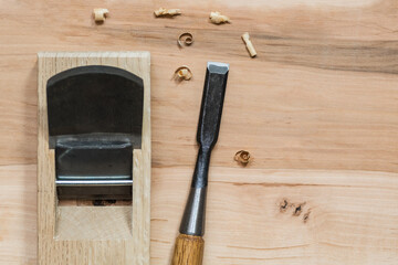 Japanese chisel and wood plane on a wooden surface with wood shavings, basic carpentry hand tools for woodworking.

