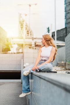 Young caucasian woman posing outdoor confident contemplating sitting outdoor backlight