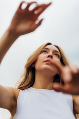 Fototapeta premium Young caucasian woman dancing outdoor gesturing with hands feeling free