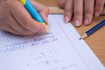 Close-up pupil's hand solves a geometric problem in a notebook. A schoolboy performs a task at the workplace. The concept of children's education, teaching knowledge, skills and abilities.