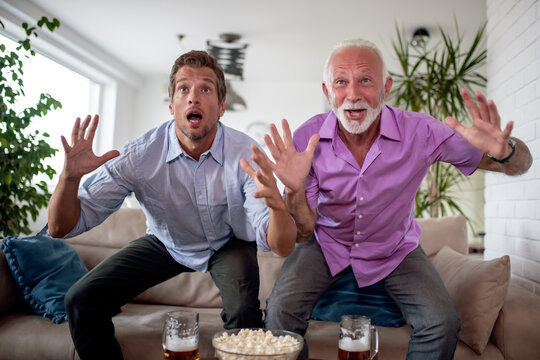 Son And Father Watching Football Game