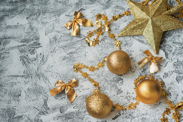 New Year's or Christmas composition of New Year's, shiny golden toys and stars on a bright textural background