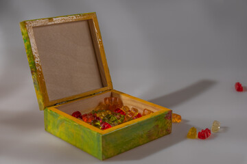 Color wooden box with cap on white background with reflection and color candy