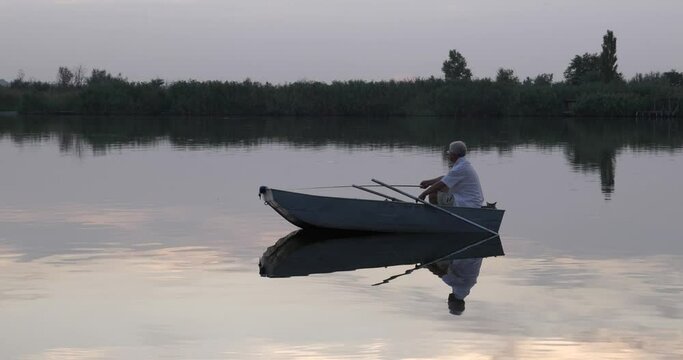Fisherman and cat fishing in boat. The first caught fish.