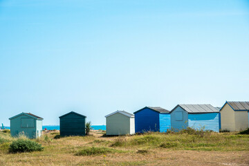 Fototapeta na wymiar colourful beach huts on an English beach in the Autumn sunshine