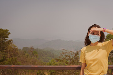 Front view point of young women traveller wearing surgical protection mask standing outdoor in daytime , travel and inspiration concept