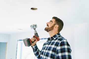 Portrait of an electrician happy worker at work install light