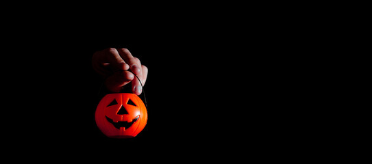Hand holding toy halloween pumpkin. Night of the dead. Copy space. Selective focus.