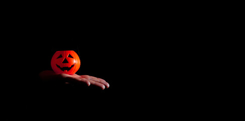 Hand holding toy halloween pumpkin. Night of the dead. Copy space. Selective focus.