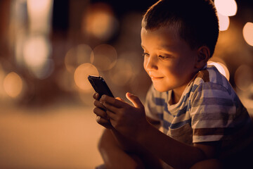 Cute boy using a smart phone outdoors