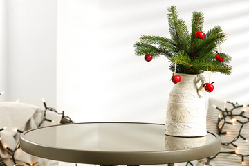 Glass round table on a background of a white wall with a shadow and Christmas decorations on a...