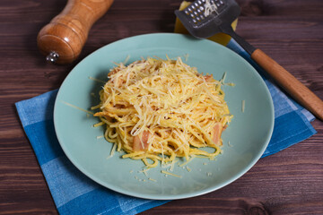 Delicious spaghetti with bacon, parmesan cheese and egg on wood background. Pasta alla carbonara. Traditional Italian cuisine.