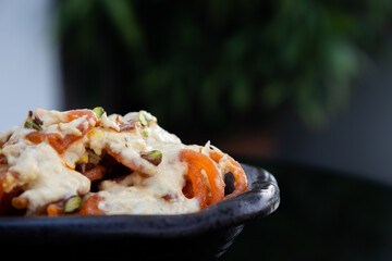 Tasty indian food item dahi vadaCrispy Sweet Jalebi, Jilapi, zulbia, mushabak or zalabia in white oval plate. selective focus. Jalebi or Jilebi Jangri