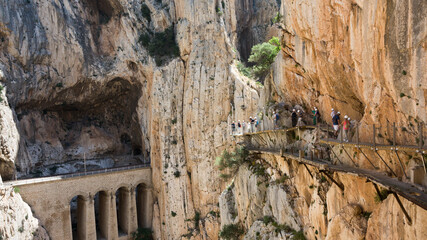 On the Caminito del Rey. Hikers walk on the footbridge that overlooks the vertiginous and narrow canyon of the Gaitanes gorges